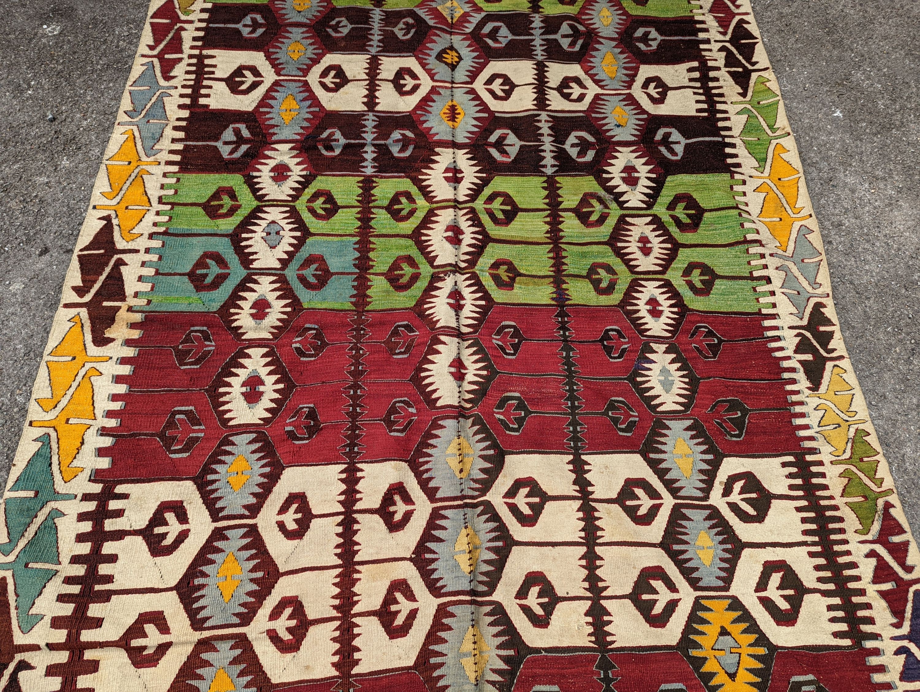 A Kelim polychrome flatweave carpet , cut centrally and re stitched, 425 x 163cm